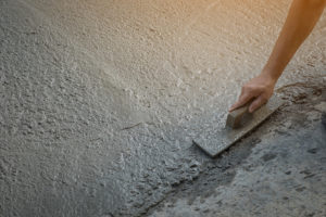 Construction workers leveling concrete pavement